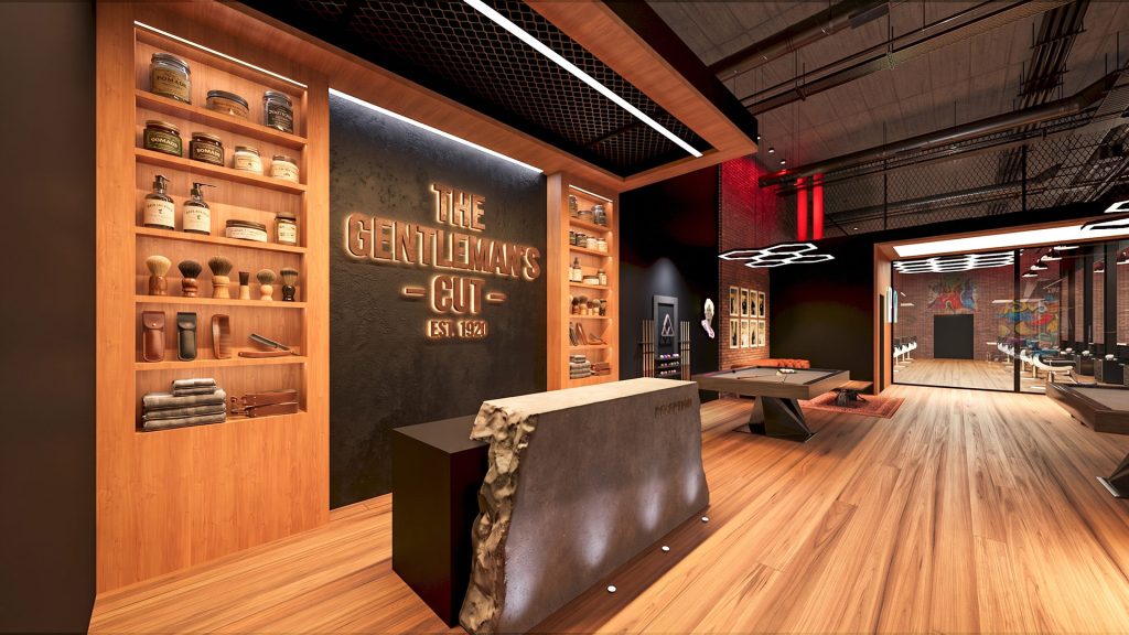 A reception desk with a stone front before warm wood shelving of grooming products, a dark wall with the shop’s name and a billiards table beyond.