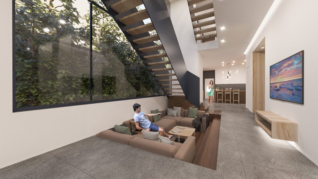 A sunken lounge with a man reading on the sofa, an open stair with wood treads and a glass wall onto the forest.