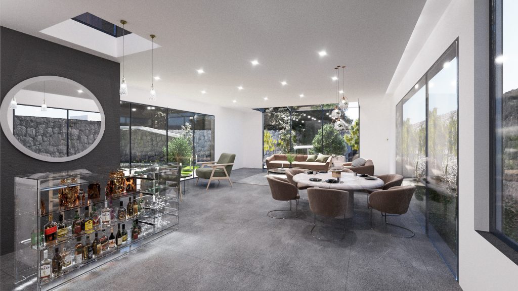 A dining area with a round table and gray chairs, a glass display of bottles and floor-to-ceiling windows onto a stone wall.