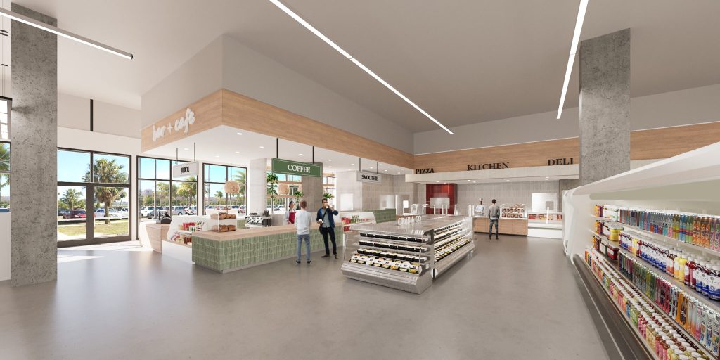 A view across the store to the deli and checkout counters, with refrigerated shelves on the right and floor-to-ceiling glass at the front.