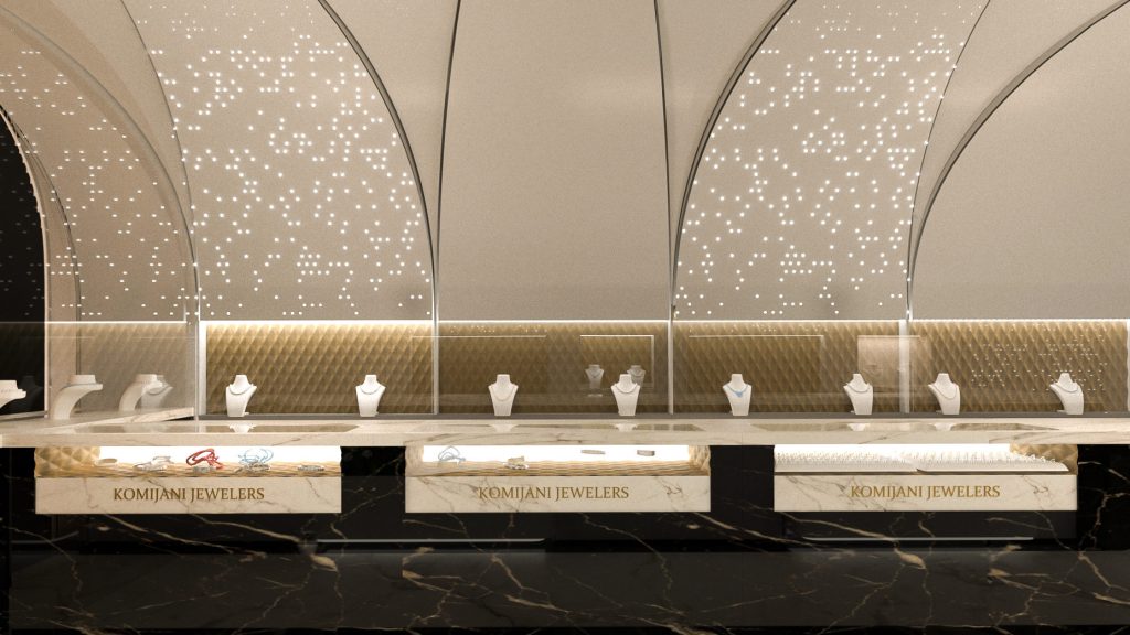 A long marble counter of jewelry displays under a row of white vaults pierced with lights.