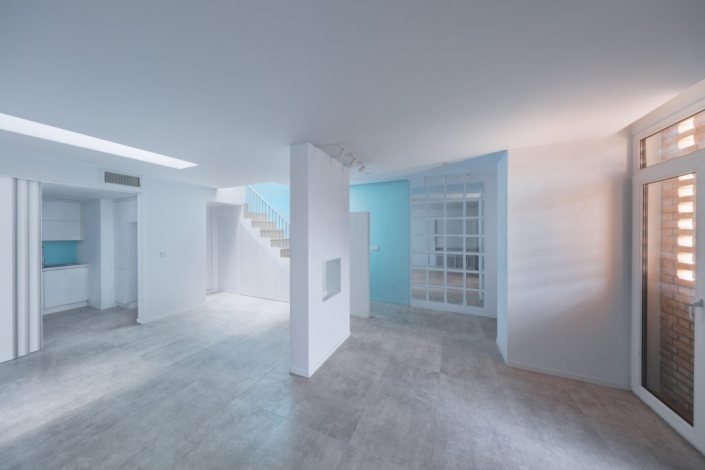 Open ground floor with a skylight and the blue stair beyond.