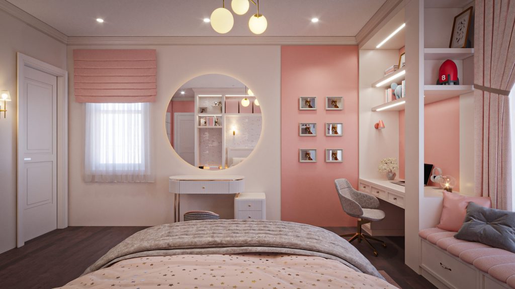 A white vanity with a round backlit mirror, framed photos on a pink wall, a window seat with cushions and the study desk.