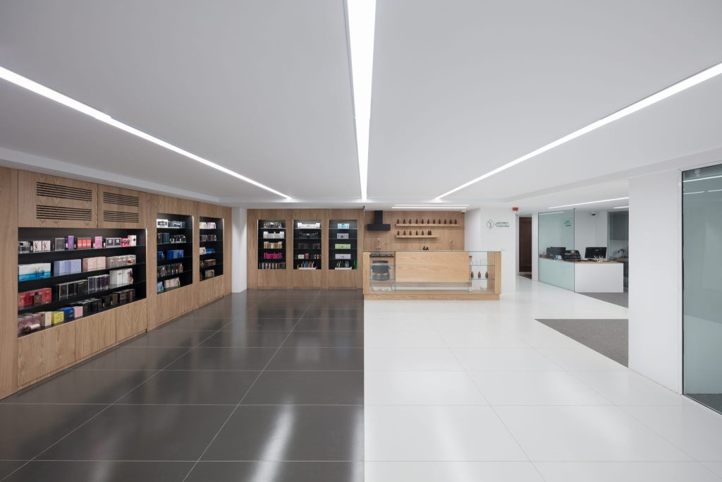 A wood-lined wall of display shelving on the upper floor, with polished floors in gray and white.