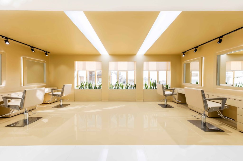 Styling chairs facing the windows under two angled light slots.