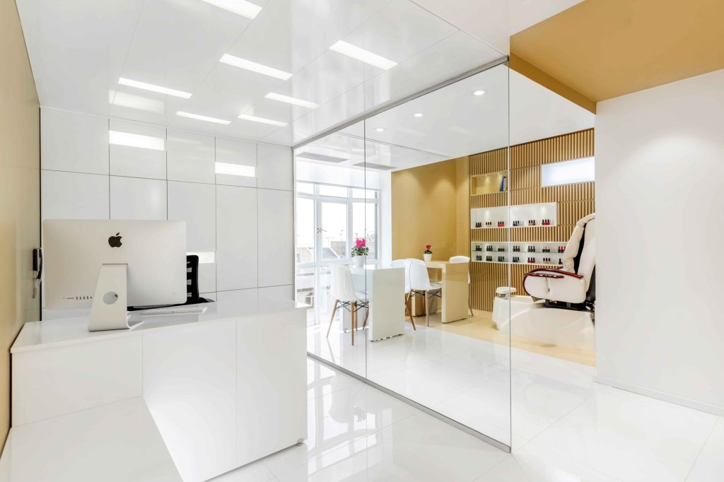 Reception desk and the pedicure area behind a glass wall.