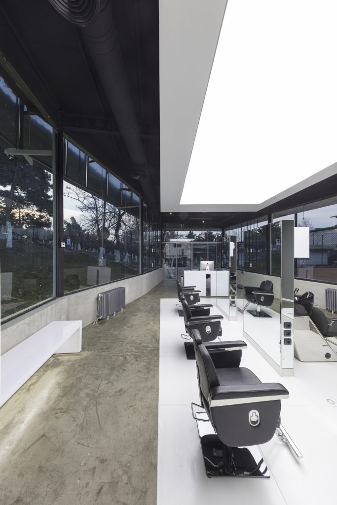 Salon chairs along the glass wall, seen from the far end.